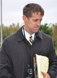 Walter McKee wearing a lanyard and holding a clipboard.